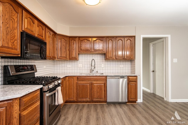 8226 Bob O Link Rd, Orland Park, IL 60462 - kitchen featuring appliances with stainless steel finishes, brown cabinetry, wood finished floors, and tasteful backsplash