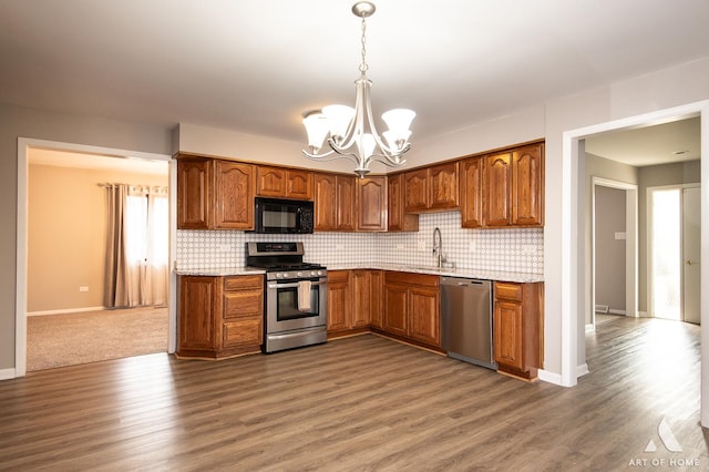 8226 Bob O Link Rd, Orland Park, IL 60462 - kitchen featuring stainless steel appliances, a chandelier, wood finished floors, backsplash, and brown cabinets