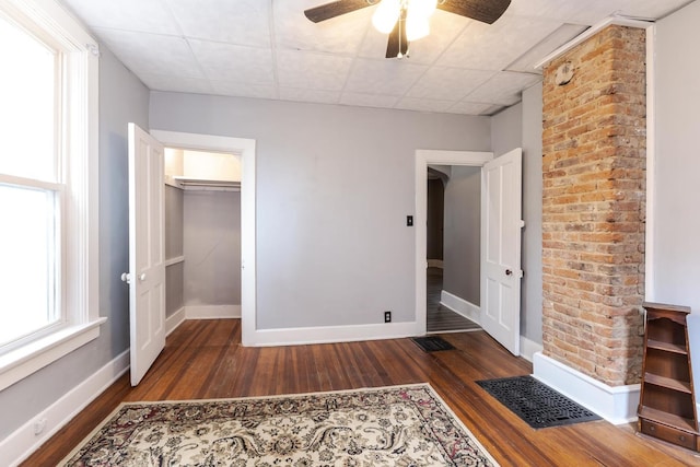 616 N Main St, Pontiac, IL 61764 - unfurnished bedroom with wood finished floors, a ceiling fan, a drop ceiling, and a walk in closet