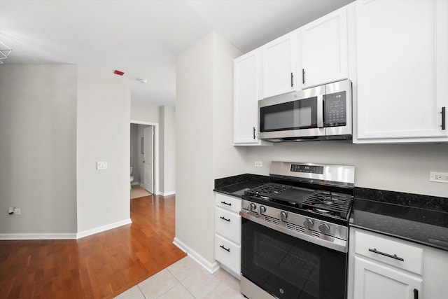 125 S Jefferson St Unit 1702, Chicago, IL 60661 - kitchen with stainless steel appliances, white cabinetry, dark stone counters, and light wood-style flooring