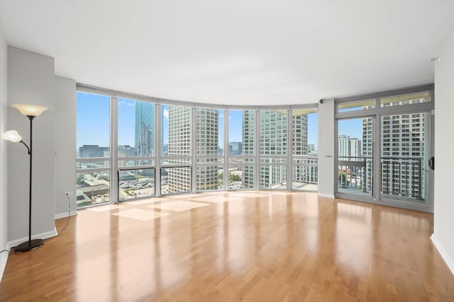 125 S Jefferson St Unit 1702, Chicago, IL 60661 - empty room featuring a view of skyline, wood finished floors, healthy amount of natural light, and expansive windows