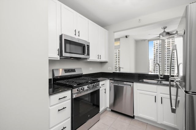 125 S Jefferson St Unit 1702, Chicago, IL 60661 - kitchen featuring stainless steel appliances, light tile patterned floors, ceiling fan, white cabinets, and dark stone countertops