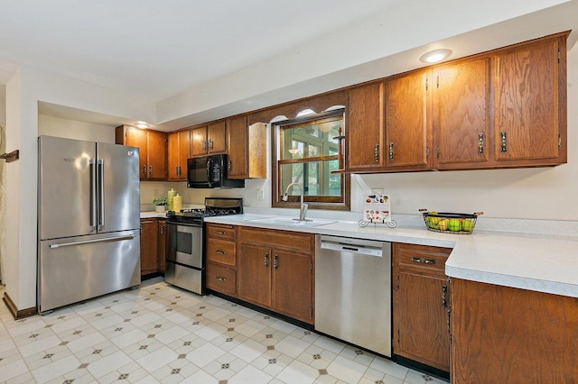 1622 Pickwick Ln, Dekalb, IL 60115 - kitchen with stainless steel appliances, light countertops, brown cabinetry, and light flooring