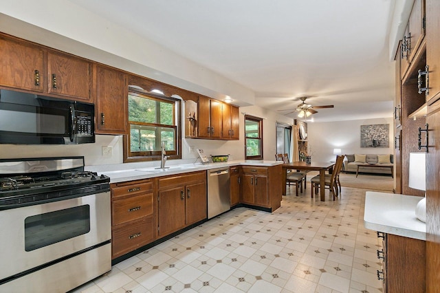 1622 Pickwick Ln, Dekalb, IL 60115 - kitchen featuring appliances with stainless steel finishes, light countertops, a ceiling fan, open floor plan, and brown cabinetry