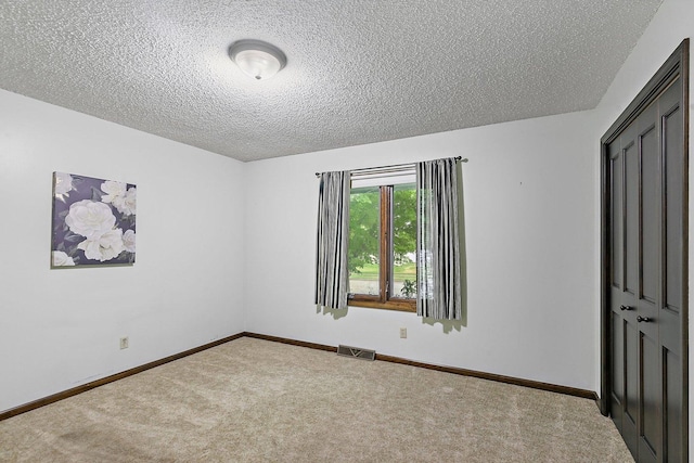 1622 Pickwick Ln, Dekalb, IL 60115 - unfurnished bedroom featuring a textured ceiling and carpet