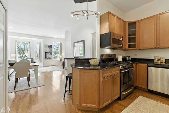 1708 W Chicago Ave Unit 3, Chicago, IL 60622 - kitchen with appliances with stainless steel finishes, light wood-type flooring, a kitchen breakfast bar, glass insert cabinets, and brown cabinetry