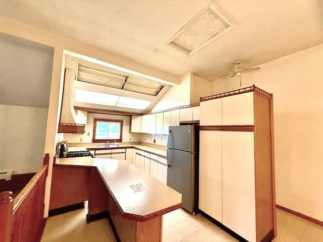 214 S Rising Rd, Champaign, IL 61822 - kitchen with freestanding refrigerator, lofted ceiling, range, light countertops, and white cabinets