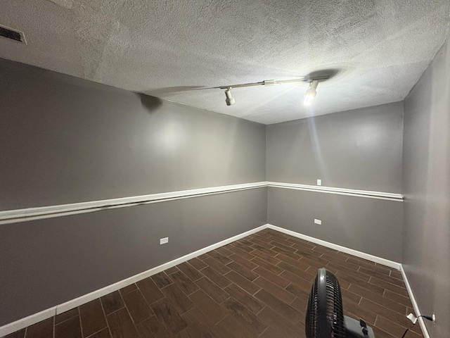 3219 Quincy Ct, Joliet, IL 60431 - empty room featuring dark wood-style flooring, rail lighting, and a textured ceiling