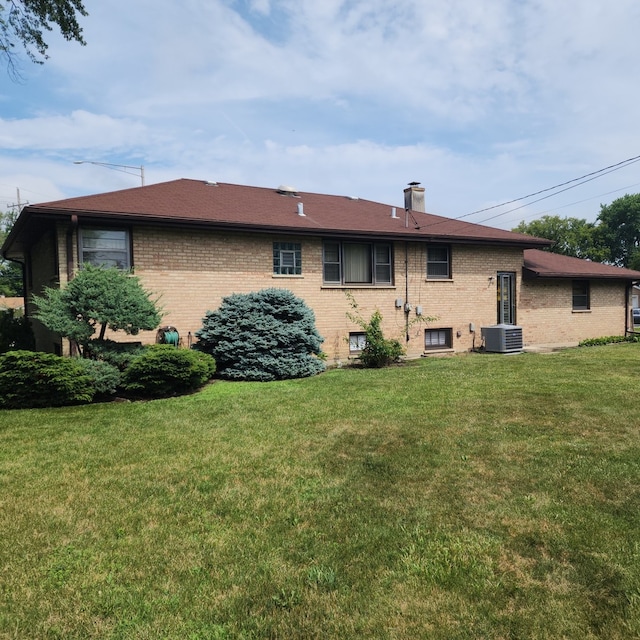 5549 W 83rd Pl, Burbank, IL 60459 - back of house featuring brick siding, a lawn, and a chimney