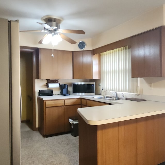 5549 W 83rd Pl, Burbank, IL 60459 - kitchen with stainless steel microwave, a peninsula, light countertops, light colored carpet, and ceiling fan