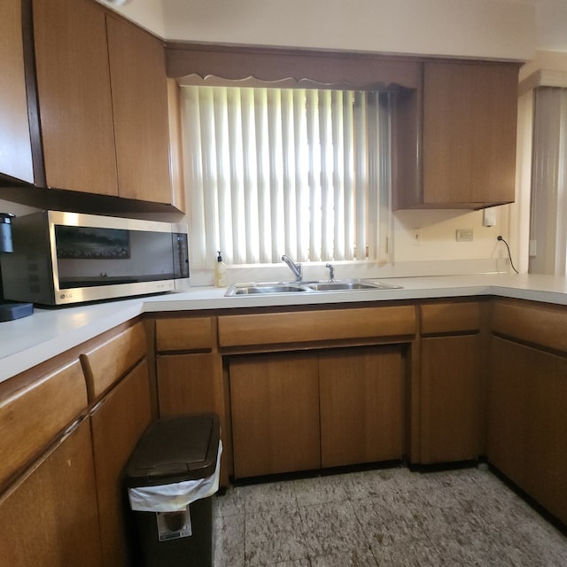 5549 W 83rd Pl, Burbank, IL 60459 - kitchen with stainless steel microwave, light countertops, and brown cabinetry