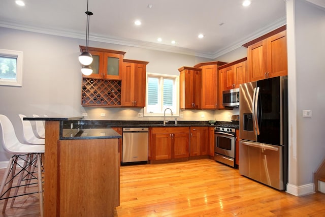 1915 N Albany Ave, Chicago, IL 60647 - kitchen with stainless steel appliances, a breakfast bar area, a peninsula, brown cabinetry, and ornamental molding