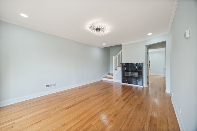 8623 S Prairie Ave, Chicago, IL 60619 - unfurnished living room featuring stairs, crown molding, wood finished floors, and recessed lighting