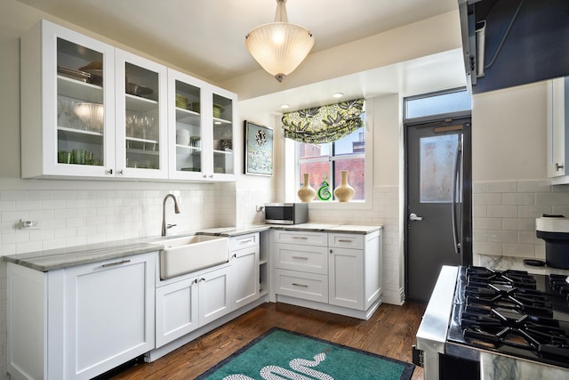 3750 N Lake Shore Dr Unit 16H, Chicago, IL 60613 - kitchen featuring white cabinetry, light stone counters, backsplash, and dark wood finished floors