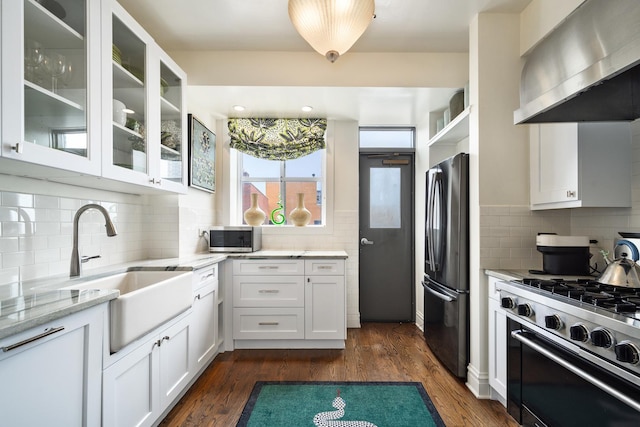 3750 N Lake Shore Dr Unit 16H, Chicago, IL 60613 - kitchen featuring stainless steel appliances, wall chimney exhaust hood, light stone countertops, tasteful backsplash, and white cabinetry