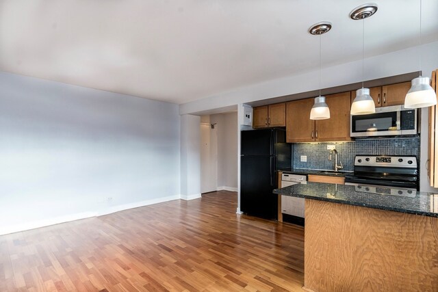 4960 N Marine Dr Unit 616, Chicago, IL 60640 - kitchen featuring appliances with stainless steel finishes, tasteful backsplash, wood finished floors, pendant lighting, and dark stone counters