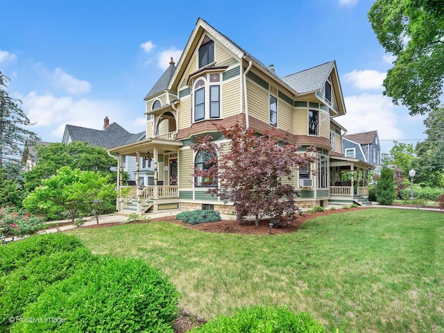 442 Du Page St, Elgin, IL 60120 - victorian home with covered porch, a front yard, a chimney, roof with shingles, and cooling unit