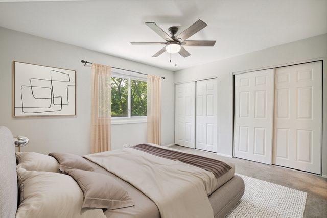 2125 Leeward Ln, Hanover Park, IL 60133 - bedroom with two closets, carpet, and ceiling fan