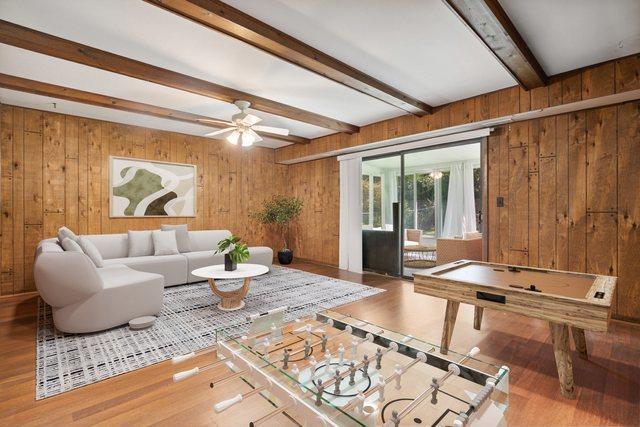 2125 Leeward Ln, Hanover Park, IL 60133 - living area with wood walls, beam ceiling, wood finished floors, and a ceiling fan