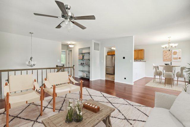 2125 Leeward Ln, Hanover Park, IL 60133 - living room featuring a chandelier, a ceiling fan, and wood finished floors