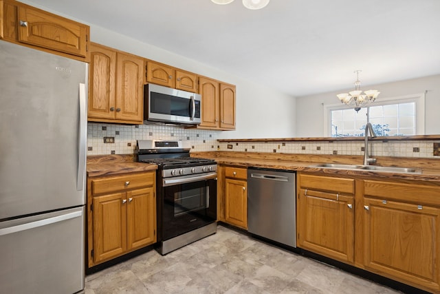 2125 Leeward Ln, Hanover Park, IL 60133 - kitchen with stainless steel appliances, decorative backsplash, a chandelier, and brown cabinets