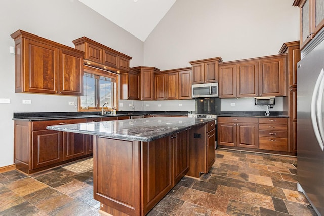 8741 W Blackthorne Way, Frankfort, IL 60423 - kitchen featuring stainless steel appliances, high vaulted ceiling, stone tile floors, a kitchen island, and dark stone countertops