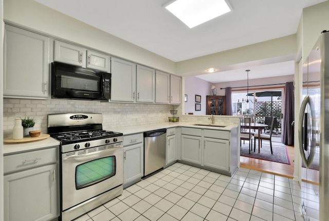 874 Dandridge Ct, Elgin, IL 60120 - kitchen with appliances with stainless steel finishes, a peninsula, light countertops, decorative backsplash, and light tile patterned floors