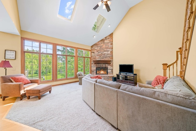 772 Wild Ginger Rd, Sugar Grove, IL 60554 - living area featuring a ceiling fan, a stone fireplace, high vaulted ceiling, a skylight, and wood finished floors