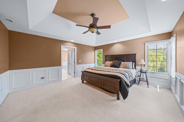 772 Wild Ginger Rd, Sugar Grove, IL 60554 - carpeted bedroom featuring a raised ceiling, a decorative wall, wainscoting, multiple windows, and ceiling fan