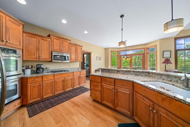 772 Wild Ginger Rd, Sugar Grove, IL 60554 - kitchen with appliances with stainless steel finishes, brown cabinetry, light wood finished floors, and recessed lighting