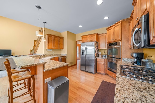 772 Wild Ginger Rd, Sugar Grove, IL 60554 - kitchen featuring stainless steel appliances, a peninsula, light wood-type flooring, light stone countertops, and a kitchen breakfast bar