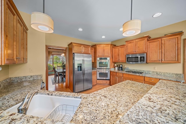 772 Wild Ginger Rd, Sugar Grove, IL 60554 - kitchen with stainless steel appliances, brown cabinetry, light stone counters, light wood-style floors, and recessed lighting