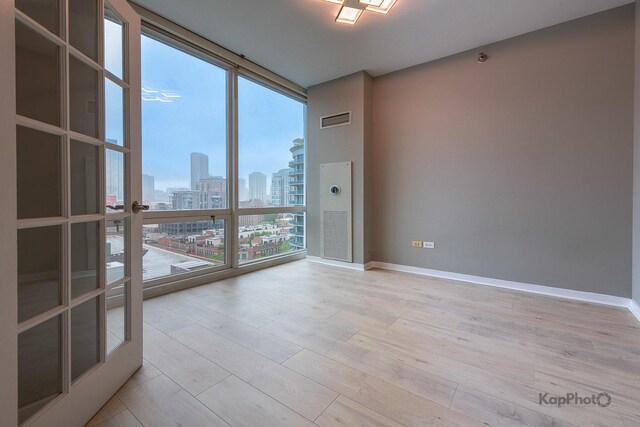 757 N Orleans St Unit 1104, Chicago, IL 60654 - unfurnished room featuring floor to ceiling windows, a view of skyline, and wood finished floors