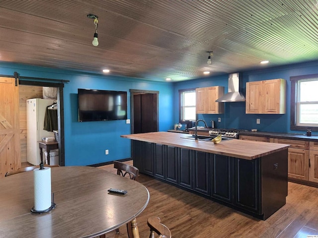 1749 N 1950th, Coatsburg, IL 62325 - kitchen with wood counters, wall chimney range hood, a barn door, a kitchen island with sink, and wood finished floors