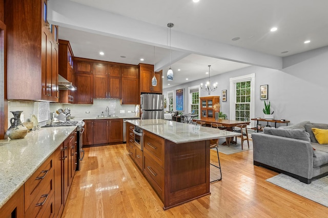 4317 N Kenneth Ave, Chicago, IL 60641 - kitchen with appliances with stainless steel finishes, ventilation hood, a breakfast bar, light wood finished floors, and tasteful backsplash