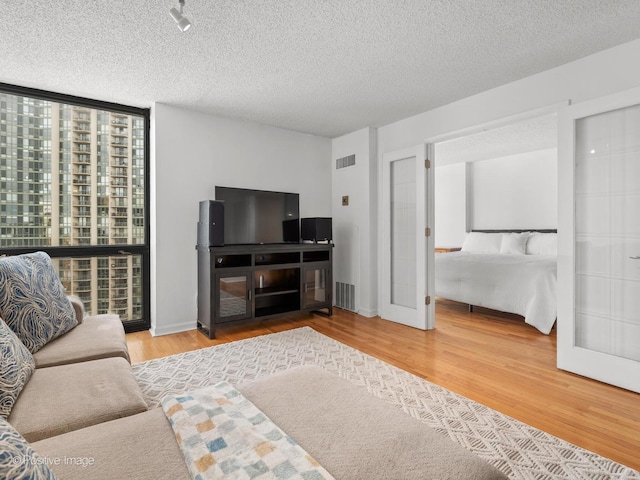 1122 N Clark St Unit 2609, Chicago, IL 60610 - living room featuring floor to ceiling windows, wood finished floors, and a textured ceiling
