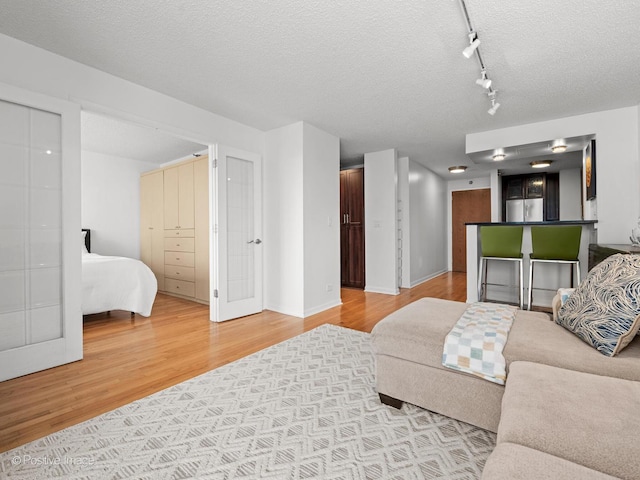 1122 N Clark St Unit 2609, Chicago, IL 60610 - living room with light wood-type flooring, a textured ceiling, and rail lighting