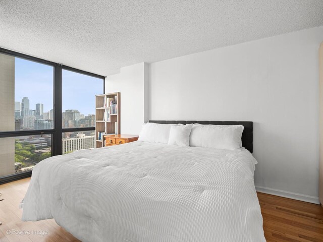 1122 N Clark St Unit 2609, Chicago, IL 60610 - bedroom with expansive windows, wood finished floors, a skyline view, and a textured ceiling
