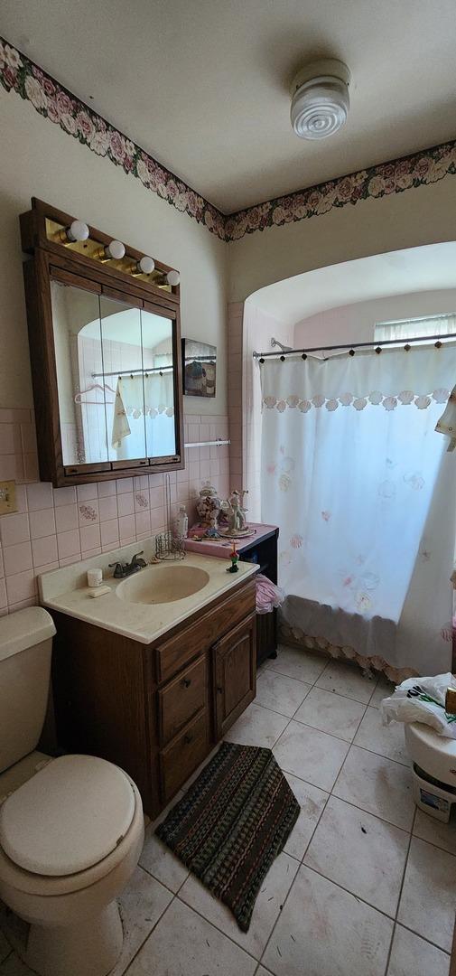 9325 S Loomis St, Chicago, IL 60620 - bathroom with vanity, tile patterned flooring, tile walls, and curtained shower