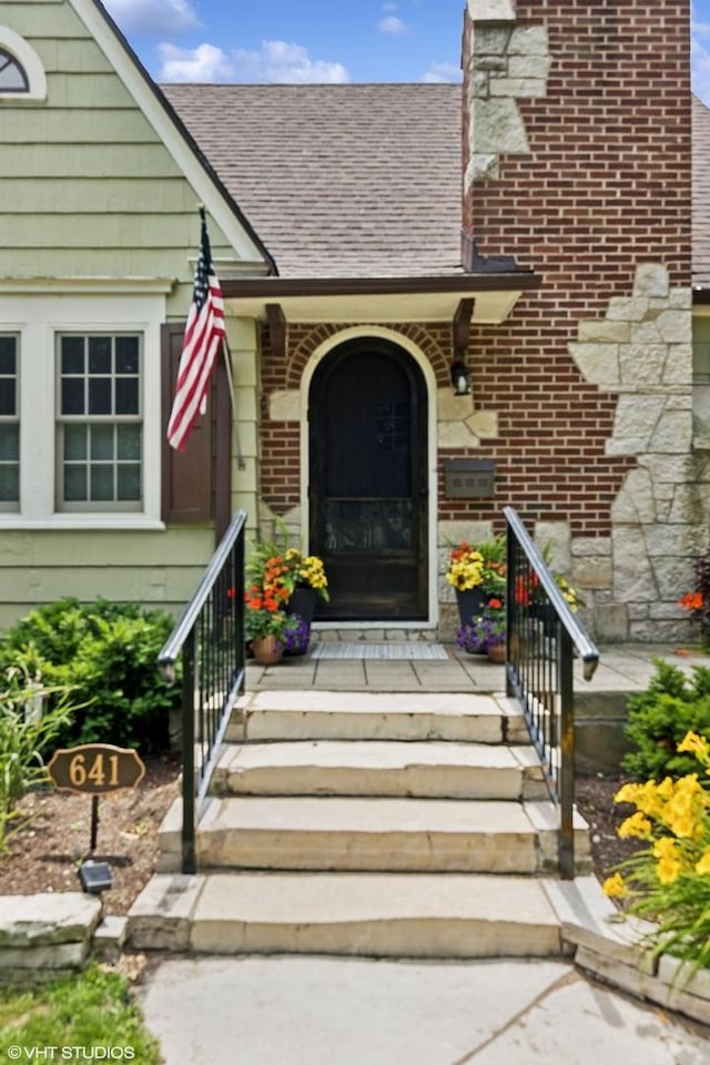 641 Highview Ter, Lake Forest, IL 60045 - view of exterior entry featuring brick siding, a shingled roof, and a chimney