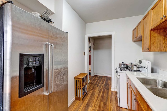2832 N Mozart St, Chicago, IL 60618 - kitchen featuring white gas range oven, refrigerator with ice dispenser, brown cabinetry, dark wood-style flooring, and light countertops
