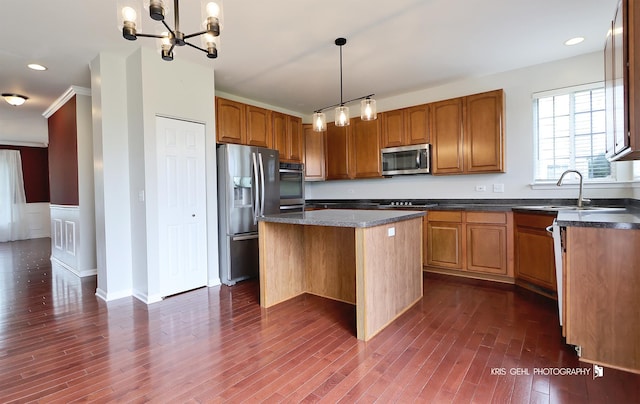 1312 Mulberry Ln, Cary, IL 60013 - kitchen with appliances with stainless steel finishes, a kitchen island, brown cabinetry, dark wood-style floors, and a chandelier