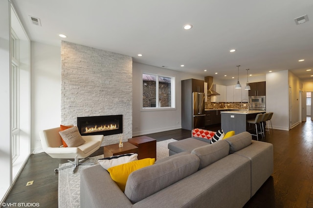 1522 W Huron St Unit 2W, Chicago, IL 60642 - living room with dark wood-type flooring, a stone fireplace, and recessed lighting