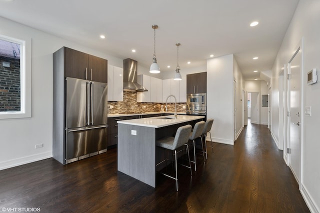 1522 W Huron St Unit 2W, Chicago, IL 60642 - kitchen with stainless steel appliances, wall chimney range hood, a breakfast bar, tasteful backsplash, and light countertops