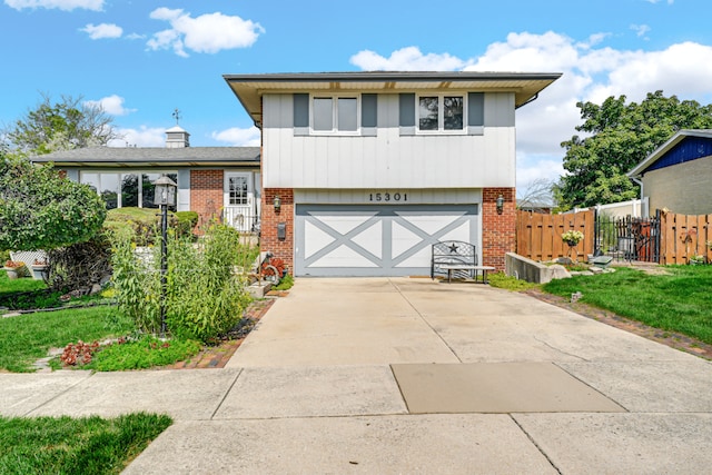 15301 Cherry Ln, Oak Forest, IL 60452 - split level home featuring brick siding, concrete driveway, and an attached garage