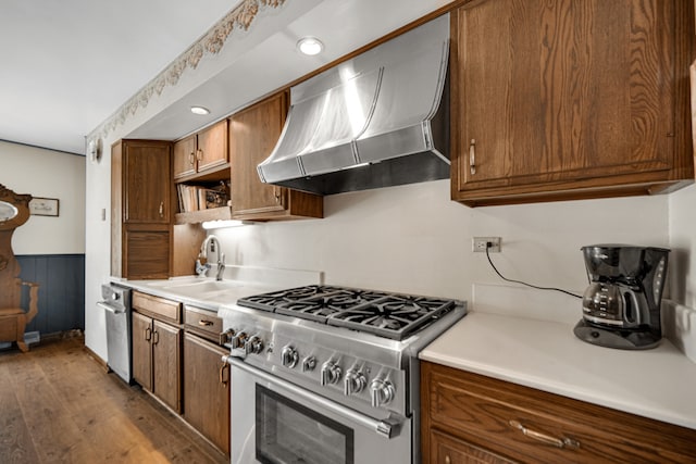 15301 Cherry Ln, Oak Forest, IL 60452 - kitchen featuring high end stove, wall chimney range hood, wood finished floors, brown cabinets, and wainscoting