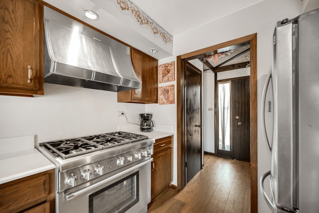 15301 Cherry Ln, Oak Forest, IL 60452 - kitchen featuring appliances with stainless steel finishes, wall chimney exhaust hood, brown cabinetry, and hardwood / wood-style floors