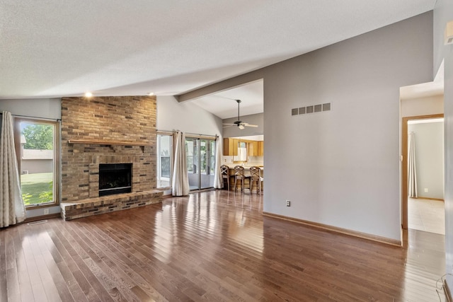 225 Mattek Ct, Dekalb, IL 60115 - unfurnished living room featuring wood finished floors, a brick fireplace, ceiling fan, and a textured ceiling