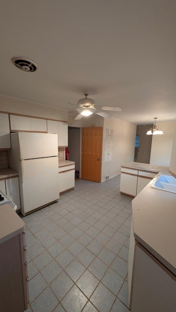 1430 Evergreen Ter, Glenview, IL 60025 - kitchen featuring freestanding refrigerator, white cabinets, light countertops, and ceiling fan