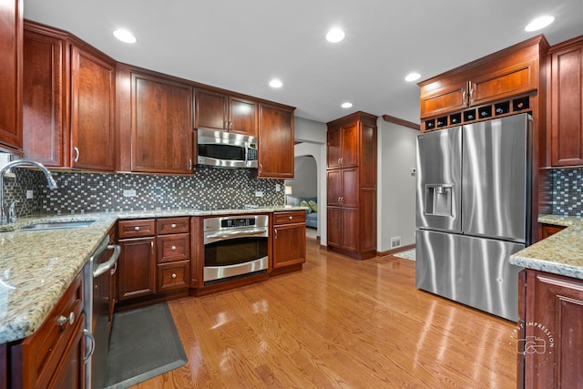 502 Burning Tree Ln, Naperville, IL 60563 - kitchen with appliances with stainless steel finishes, light wood-type flooring, decorative backsplash, light stone countertops, and recessed lighting